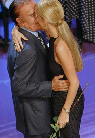 Cecilia Bolocco y Carlos Menem se besan durante el tira y afloja del programa de televisión.