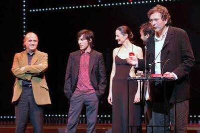 Gerardo Herrero, ante el micrófono,  recoge la Biznaga de Oro a la mejor película por Los aires difíciles, acompañado por los actores de la película.