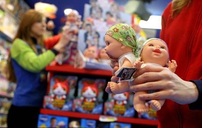 Una dependienta con dos mu&ntilde;ecos Baby Pelones en una tienda de Madrid.