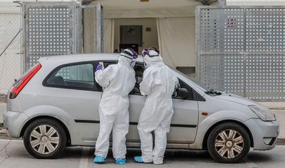 Dos sanitarios realizan una prueba PCR a una persona desde su vehículo a las puertas del Hospital de Campaña próximo al de La Fe, en Valencia (España), el lunes 25 de enero.