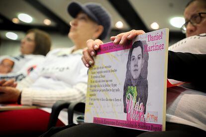 Una mujer sostiene una imagen de Daniel Martínez, uno de los jóvenes asesinados del caso 03.