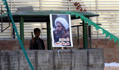 Un miliciano Huthi hace guardia junto al póster del clérigo chií ejecutado durante una manifestación contra Arabia Saudí, este jueves en Yemen.