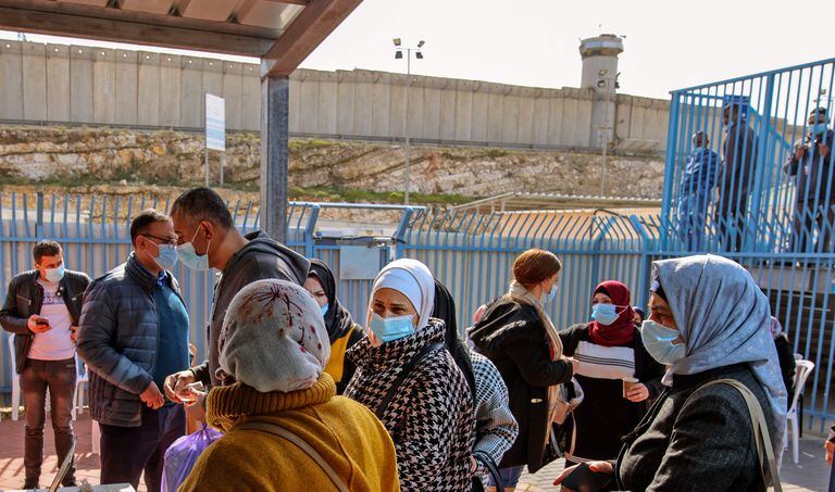 Varios palestinos esperan a ser vacunados por sanitarios israelíes, el martes en el paso de Qalandia, entre Cisjordania e Israel.