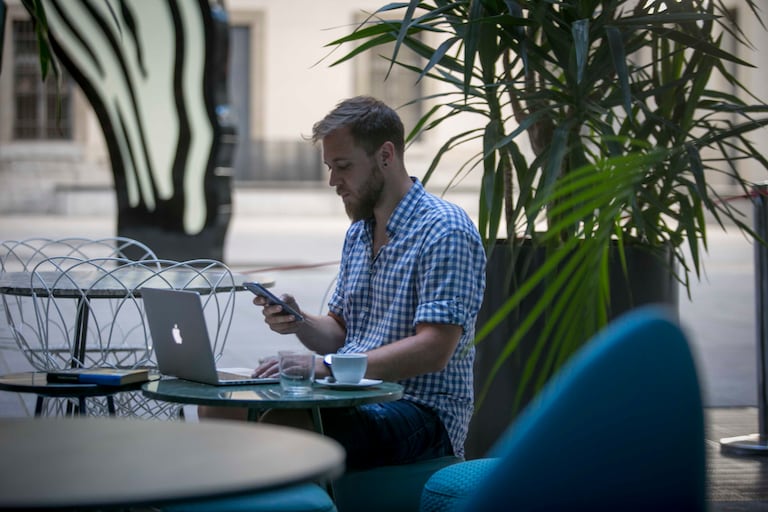 Un joven teletrabaja desde la terraza del restaurante Nubel en el Centro de Arte Reina Sofía.