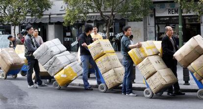 Comerciantes chinos transportan sus mercanc&iacute;as en el barrio madrile&ntilde;o de Lavapi&eacute;s.