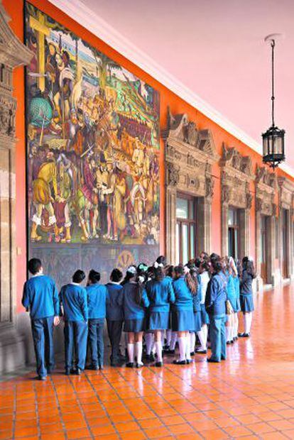 Escolares frente al mural de Diego Rivera ‘La colonización o llegada de Hérnan Cortés a Veracruz’, en el Palacio Nacional, en México DF.