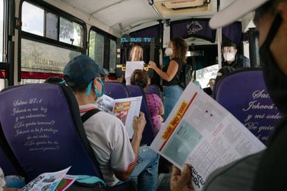 Pasajeros de un autobús en Caracas leen el periódico distribuido por El Bus TV. Reporteros de esa organización, en su mayoría estudiantes de periodismo, se suben a autobuses a narrar noticias a viva voz –ahora con micrófonos y cornetas como una medida de seguridad en pandemia– con un marco de cartón que simula un televisor.