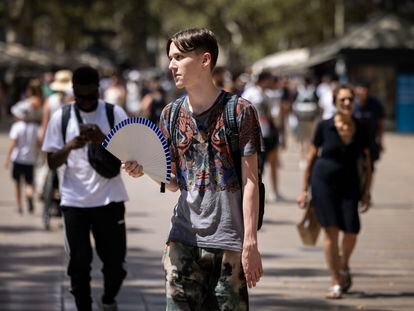 Un joven se abanica el pasado 18 de julio, en plena ola de calor, en la Rambla de Barcelona.