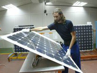 Un trabajador de Isofot&oacute;n manipula c&eacute;lulas fotovoltaicas.