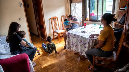 Amanda, sus tres hijos y sus padres, en la sala de su casa en Leganés (Madrid).