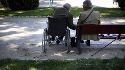 Dos ancianos sentados en un parque.