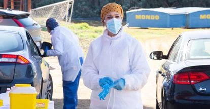 Una sanitaria entre dos filas de coches de personas mayores que esperan para ser vacunados con la vacuna de Pfizer en el exterior del Polideportivo Municipal, en Villafranca De Los Barros, Badajoz, Extremadura (España).