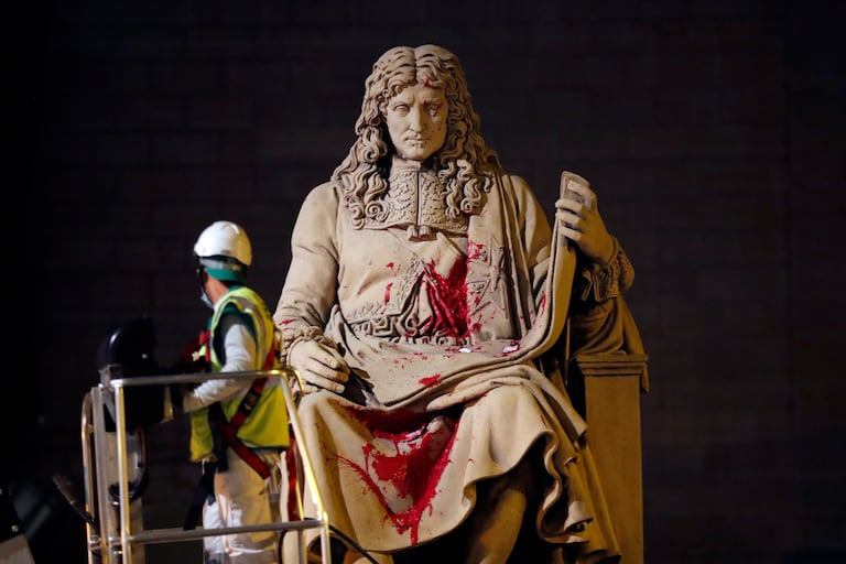 Un operario municipal limpia la estatua de Colbert ante la Asamblea Nacional, en París, en la noche del martes.