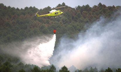 Un helic&oacute;ptero trabaja en el incendio, cerca de la Veguilla.
