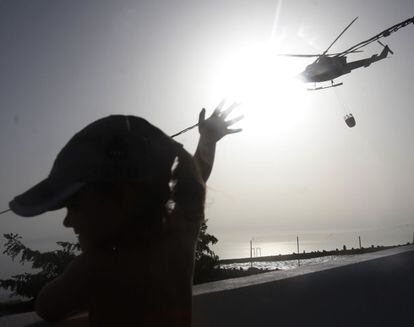 Un helicóptero de la toma de agua de una piscina para seguir la extinción del incendio forestal que comenzó hace cinco días en el sur de Tenerife, el 19 de julio de 2012.