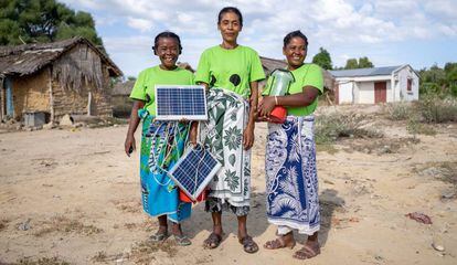 Marie (izquierda), Marinasy (centro) y Tsiampoizy (derecha) son tres mujeres de Ranomay. En la foto, muestran los paneles y las lámparas solares que ellas mismas instalan y reparan. Viajaron hasta India para formarse como ingenieras solares.