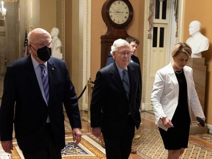 El líder de los republicanos en el Senado, Mitch McConnell (en el centro), junto al senador demócrata por Vermont Patrick Leahy (a la izquierda), en los pasillos del Capitolio, antes de la aprobación de la ley.

