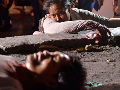 Una mujer llora junto al cuerpo de un familiar quien fue tiroteado mientras mendigaba en una calle de Manila (Filipinas).
