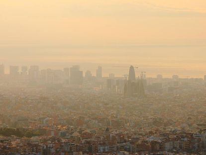 Vista aérea de Barcelona, con la Sagrada Familia y la Torre Agbar en el centro, apenas visibles por la contaminación atmosférica. |
