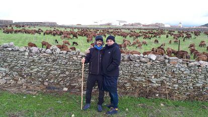 Gabi Martínez, autor d'aquest reportatge, i el cineasta Agustí Villaronga en un prat, amb un ramat d'ovelles negres a Extremadura.