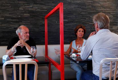 Un restaurante de Bruselas prueba una barrera de plexiglás entre las mesas.