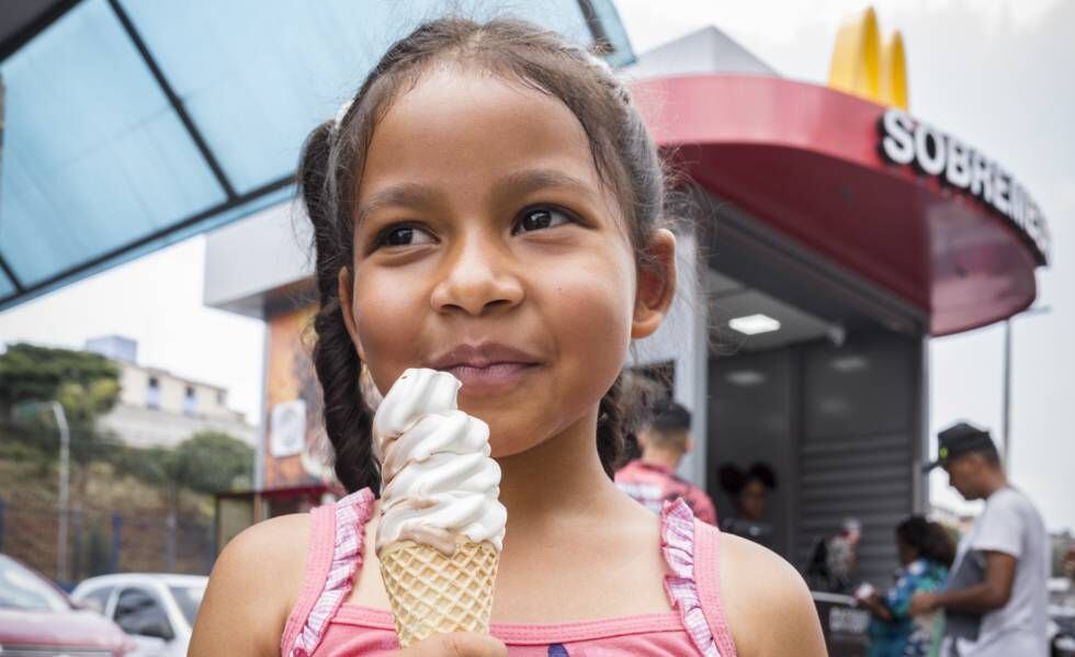 Una niña prueba un helado una mañana de noviembre en Cidade Tiradentes