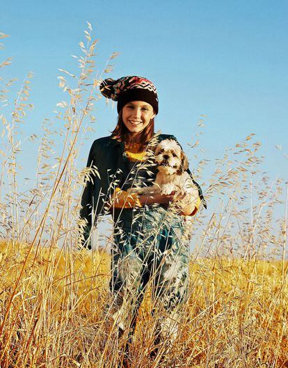 Carolina, con Gilda en brazos, lleva peto vaquero con parches de Pepe Jeans, cazadora de DKNY, jersey de punto de Mayoral y gorro con pompón de El Corte Inglés.