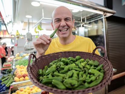 El mago, presentador y humorista Jandro, este lunes con una cesta de pimientos de Padrón en el Mercado Central de Valencia.