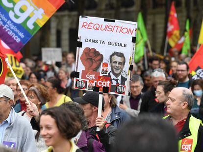 Un cartel con la imagen de Macron y la leyenda "Requisas en tu cara" exhibido durante una manifestación sindical este martes en París.