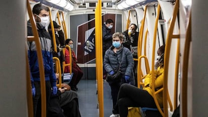 Usuarios protegidos con mascarillas en el interior de un vagón del metro de Madrid, en 2020. 