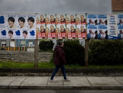 Una persona pasa junto a carteles con propaganda electoral en A Illa de Arousa (Pontevedra).
