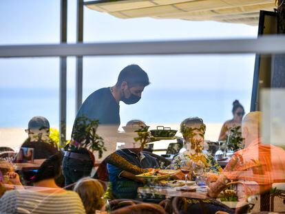 Un camarero sirve a unos clientes de una mesa de un restaurante del Paseo Marítimo de Platja d'Aro.