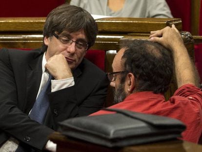 Carles Puigdemont habla con el diputado de la CUP, Benet Salellas en el pleno del debate de política general en el Parlament.