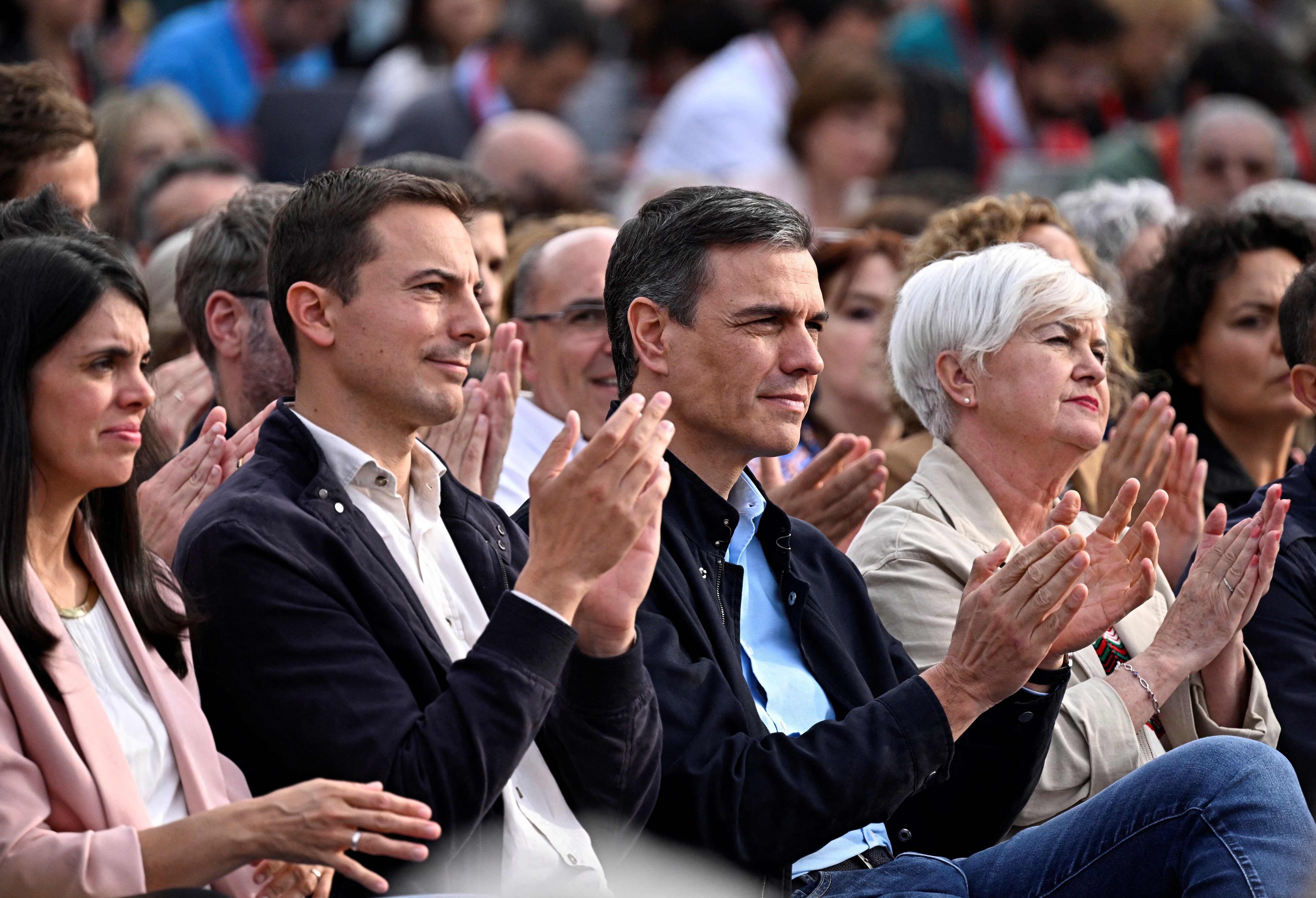 Spain's Prime Minister Pedro Sanchez applauds next to PSOE's candidate for Madrid regional president Juan Lobato (C,L) during an electoral meeting of Spain's Socialist Party (PSOE) in Madrid on May 25, 2023 ahead of the May 28 regional and municipal election. (Photo by JAVIER SORIANO / AFP)