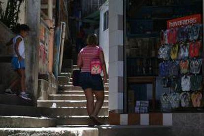 Una mujer camina frente a una tienda en la favela Dona Marta en Río de Janeiro (Brasil). EFE/Archivo