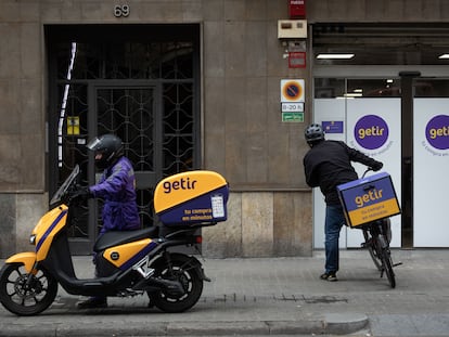 Dos repartidores ante un local de la compañía Getir en Barcelona, en marzo de 2022.