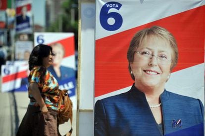 Una mujer camina al lado de la propaganda política de Bachelet.