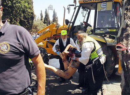 Los servicios de seguridad sacan el cadáver del atacante palestino de la excavadora.