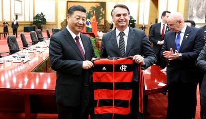 El presidente brasileño, Jair Bolsonaro, regala a su homólogo chino Xi Jinping una chaqueta del Flamengo, durante un encuentro celebrado en Pekín en 2019. 