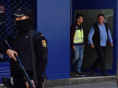 El presidente del Huesca, Agustín Lasaosa, junto a un policía a su salida de las oficinas del club tras ser detenido en mayo de 2018 durante la Operación Oikos.