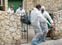 Trabajadores de una empresa funeraria de Palma trasladan un cadáver equipados con monos y mascarillas.