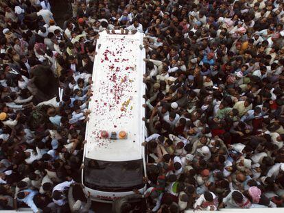 Partidarios de Benazir Bhutto rodean la ambulancia en la que fue trasladada.