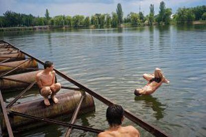 Tres jóvenes se divierten en un parque en Donetsk, vacío por los ataques y del lado prorruso.