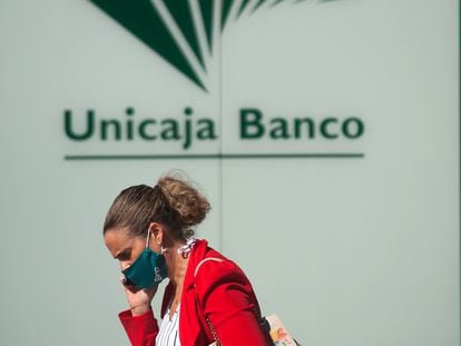 Una mujer ante el logo de Unicaja.