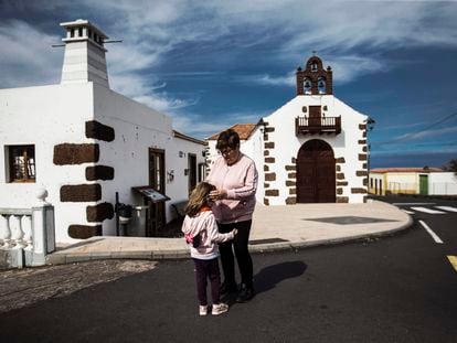 Una mujer y una niña frente a la parroquia de Nuestra Señora del Carmen, en Las Tricias (Garafía).