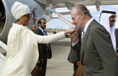El Rey don Juan Carlos saluda a Mozah Bint Nasser, esposa del emir de Catar, Hamad Bin Jalifa al-Thani (a la derecha de la imagen), a su llegada al aeropuerto de Barajas.