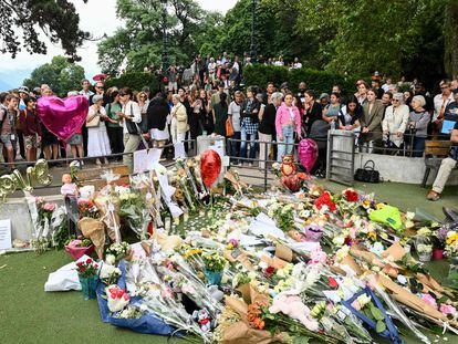 Un grupo de personas observa el homenaje espontáneo con ramos, peluches y globos a las víctimas del ataque de este jueves en los Jardines de Europa de la ciudad francesa de Annecy.