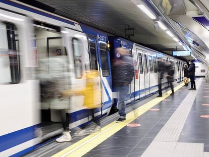 Varias personas esperan la llegada de un vagón del Metro de Madrid.