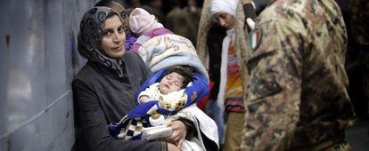 Un soldado italiano auxilia a inmigrantes rescatados a 50 km de Lampedusa.