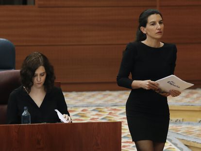 La portavoz de Vox en la Asamblea, Rocío Monasterio (derecha) pasa junto a la presidenta de la Comunidad de Madrid, Isabel Díaz Ayuso.